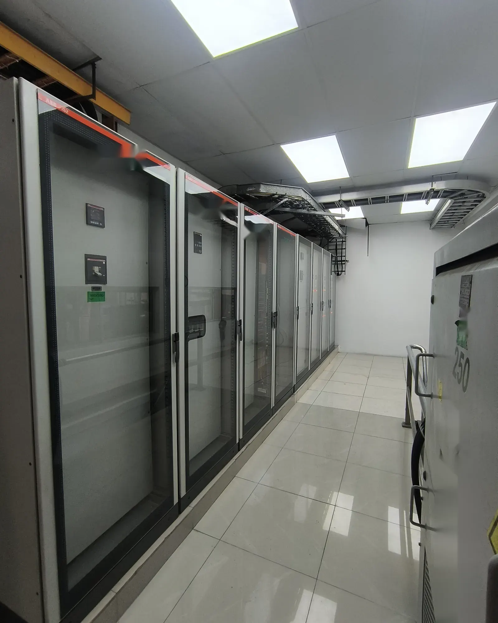 Pasillo de un cuarto eléctrico con tableros de distribución y control